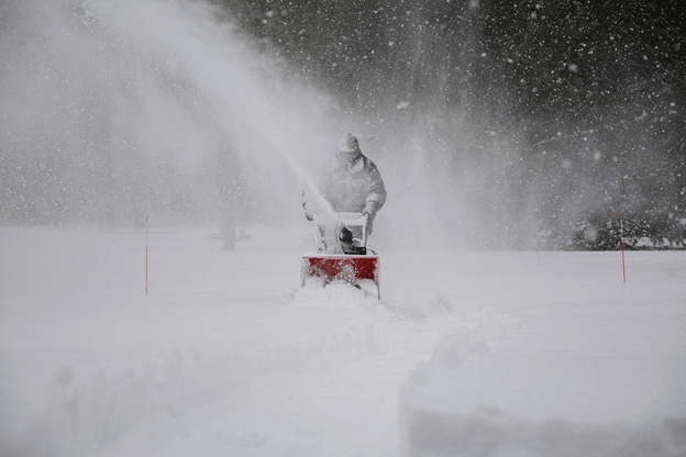 Snow Removal-A person clearing up snow from a path.