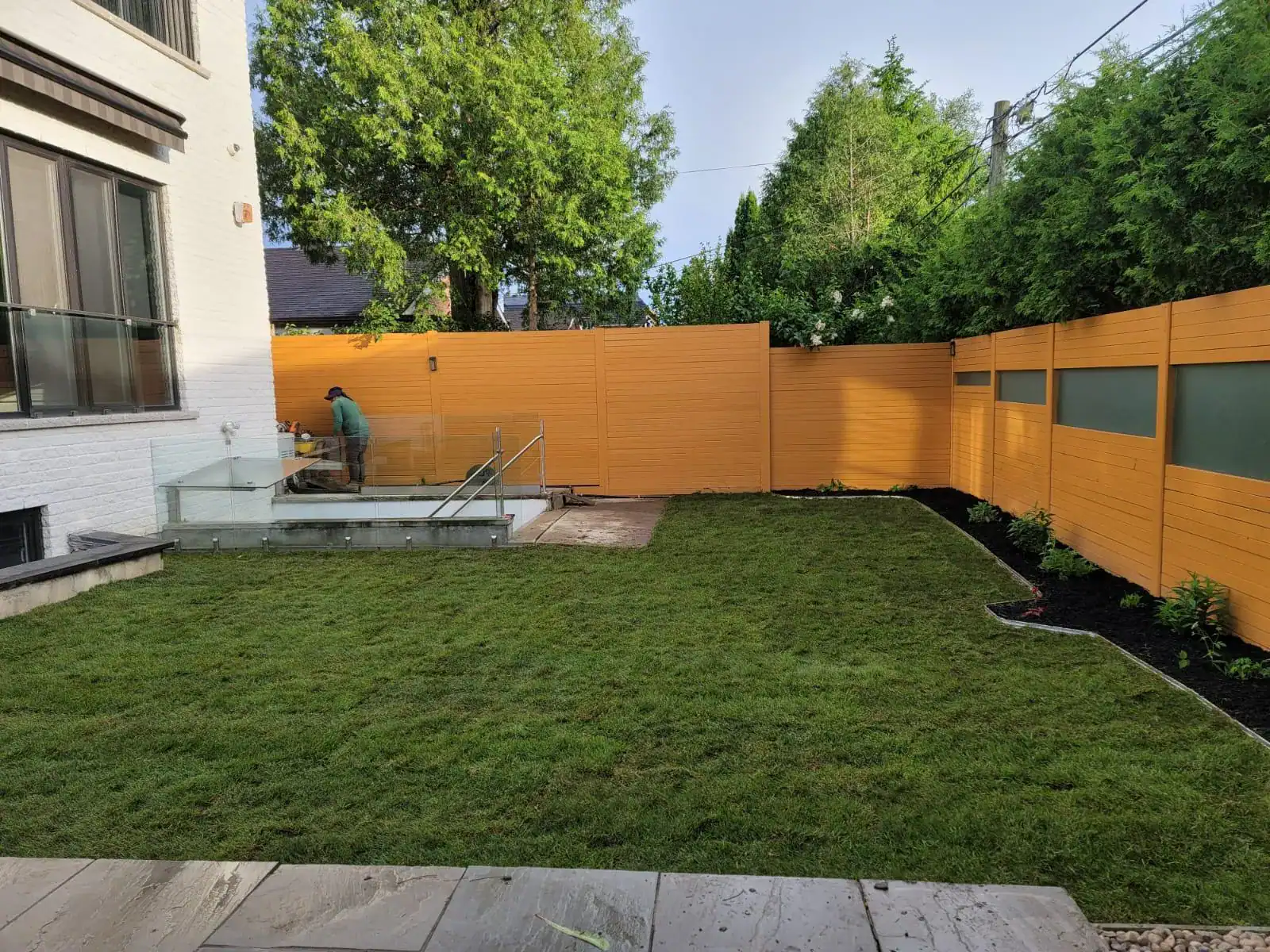 Professional landscaper laying sod in a residential yard, showcasing the installation process